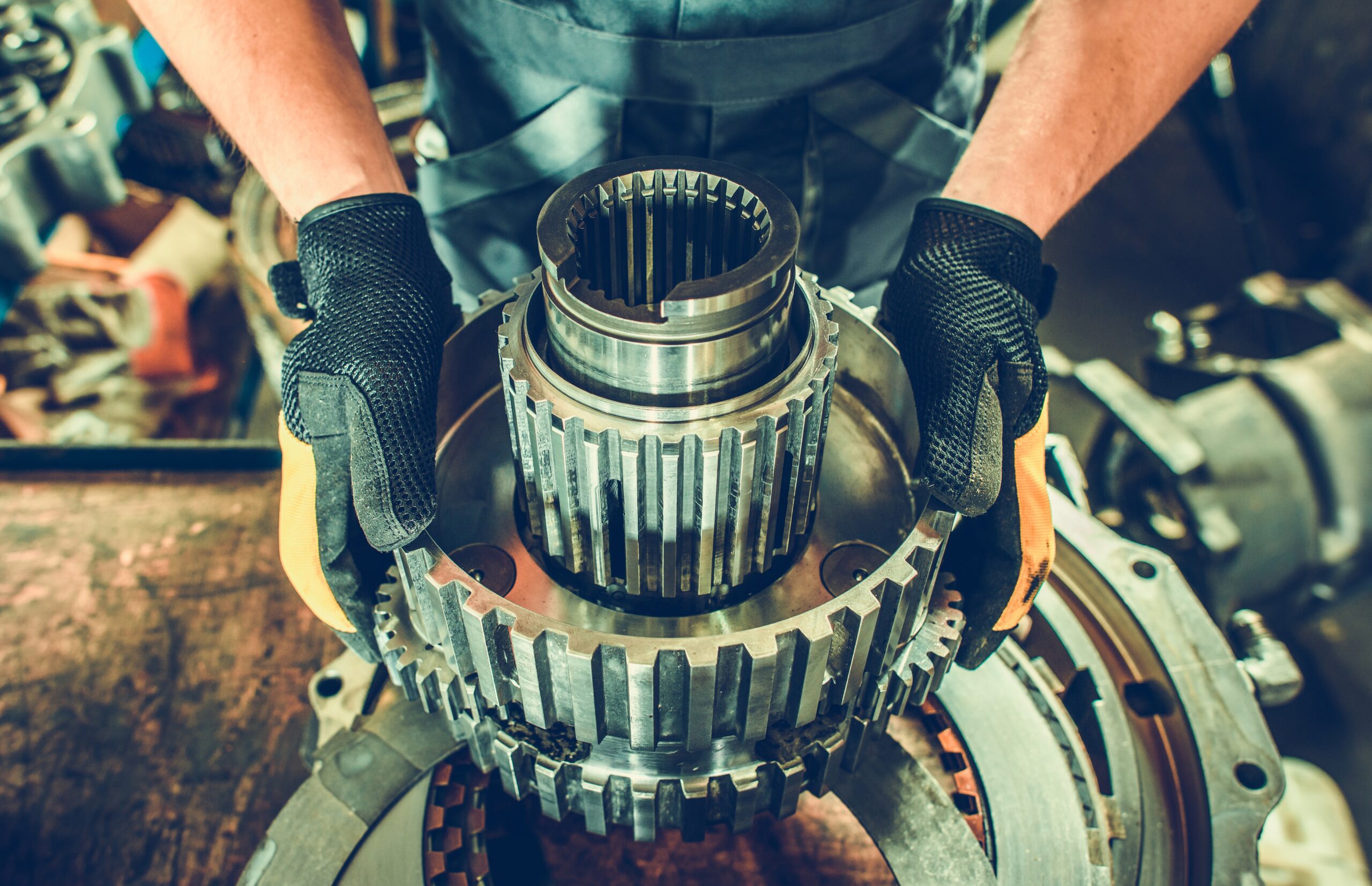 Heavy Duty Mechanic with Industrial Grade Vehicle Part in Hands.
